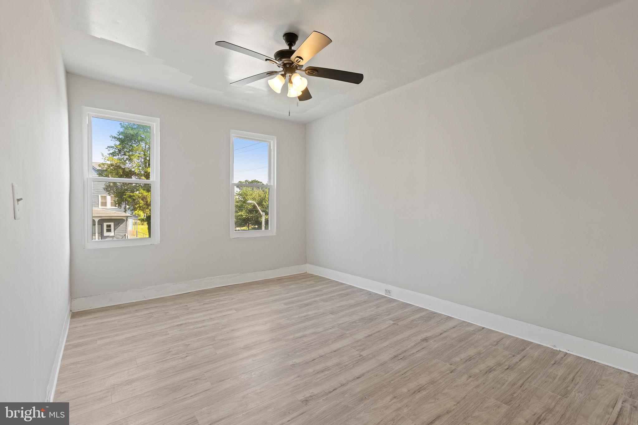 3003 Clifton Avenue Baltimore, MD 21216 - Photo 15 of 28 an empty room with windows and chandelier fan