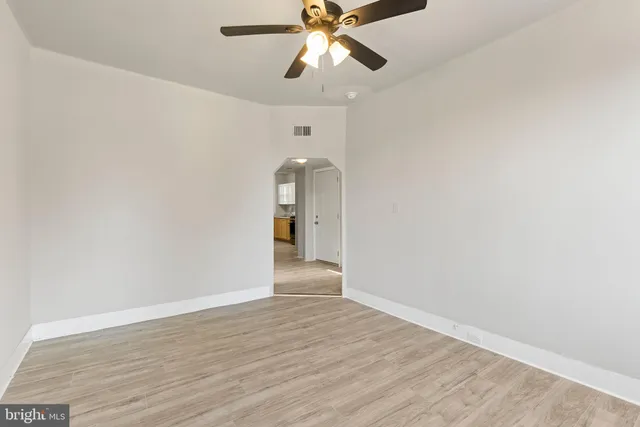 a view of an empty room and window and wooden floor