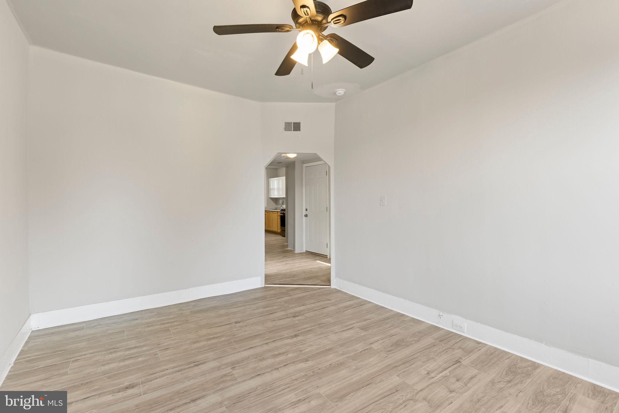 3003 Clifton Avenue Baltimore, MD 21216 - Photo 16 of 28 a view of an empty room and window and wooden floor