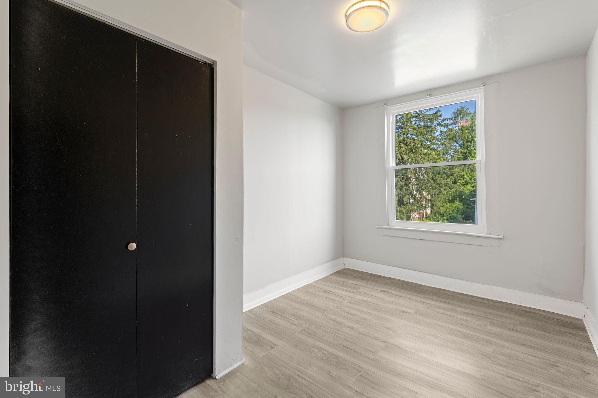 3003 Clifton Avenue Baltimore, MD 21216 - Photo 19 of 28 a view of an empty room with wooden floor and a window