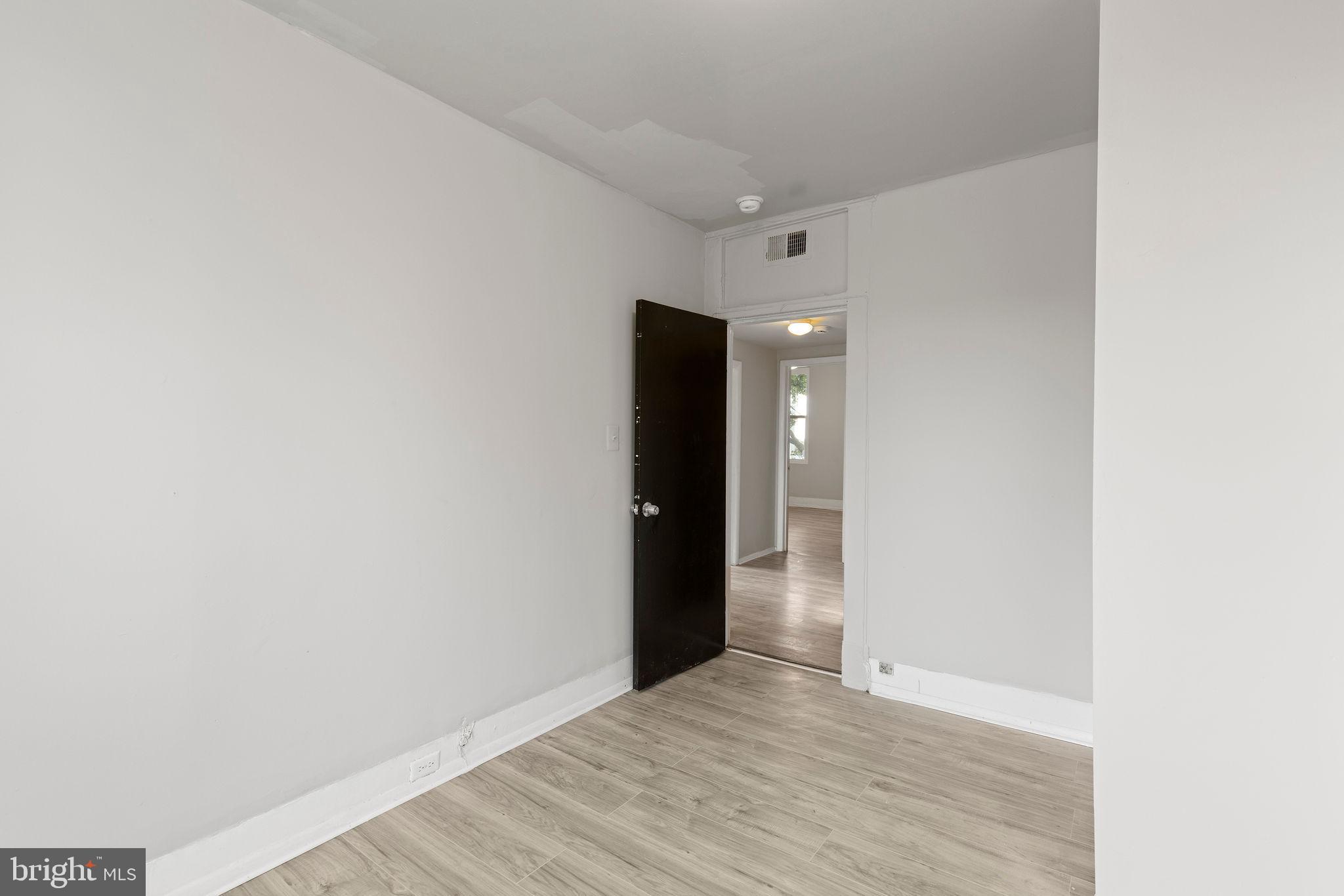 3003 Clifton Avenue Baltimore, MD 21216 - Photo 20 of 28 a view of an empty room with wooden floor