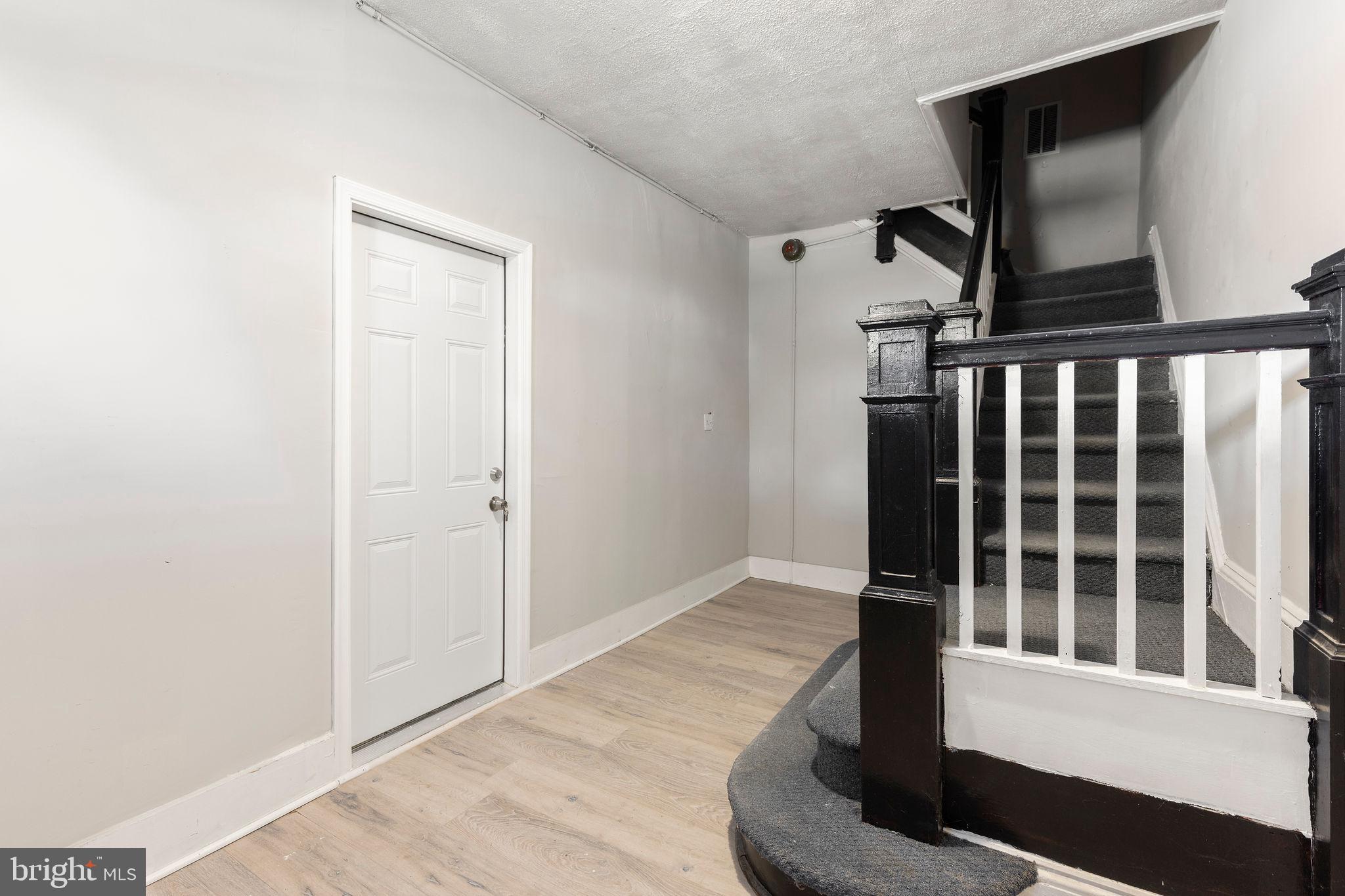 3003 Clifton Avenue Baltimore, MD 21216 - Photo 5 of 28 a view of wooden floor and staircase in a room
