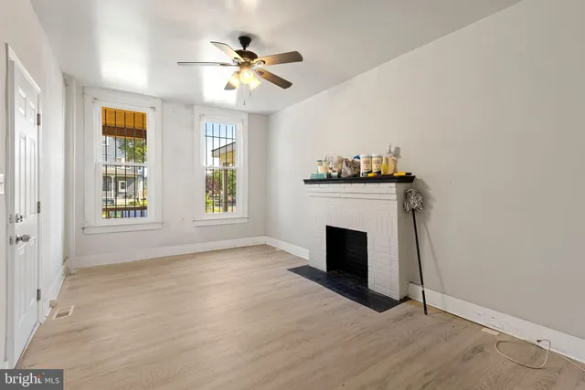 a view of an empty room with a fireplace and a window