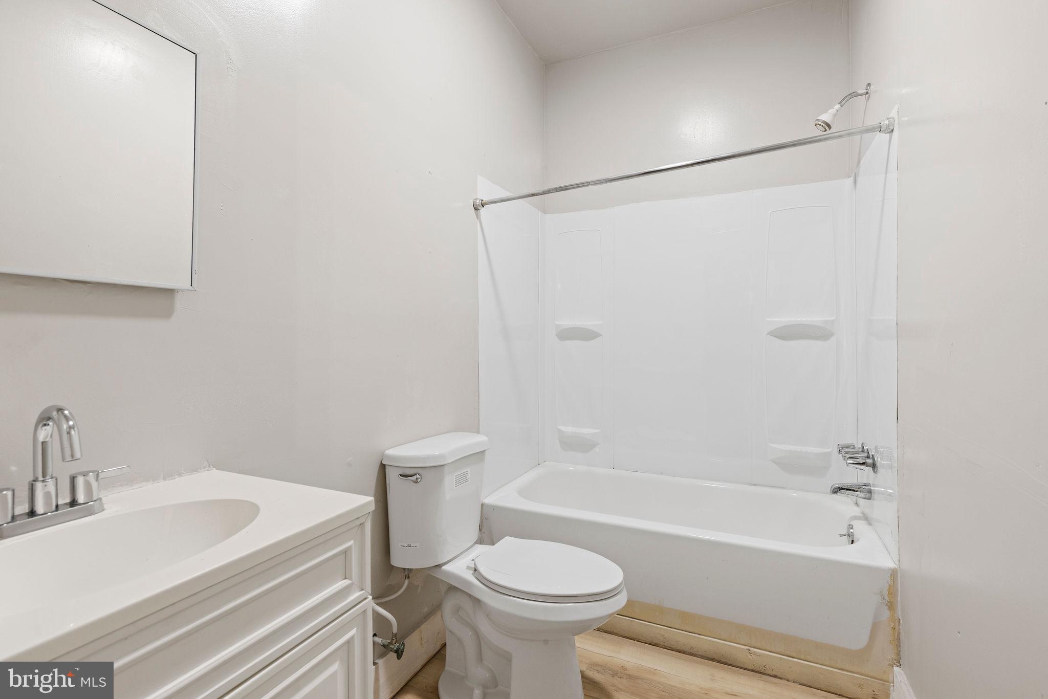 3003 Clifton Avenue Baltimore, MD 21216 - Photo 10 of 28 a bathroom with a sink a toilet and a bathtub