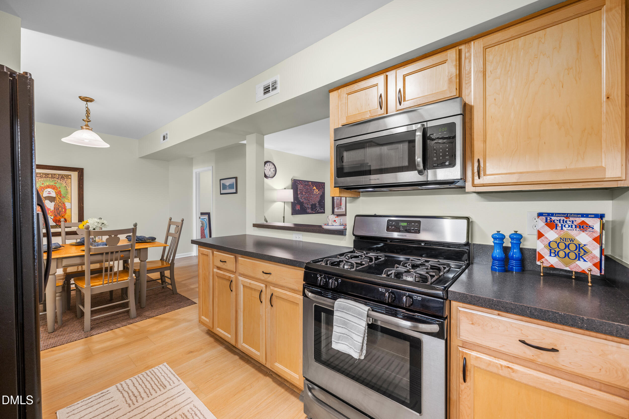 1312 Hillbrow Lane, Unit 203 Raleigh, NC 27615 - Photo 7 of 26 a kitchen with stainless steel appliances granite countertop a stove a sink and a microwave