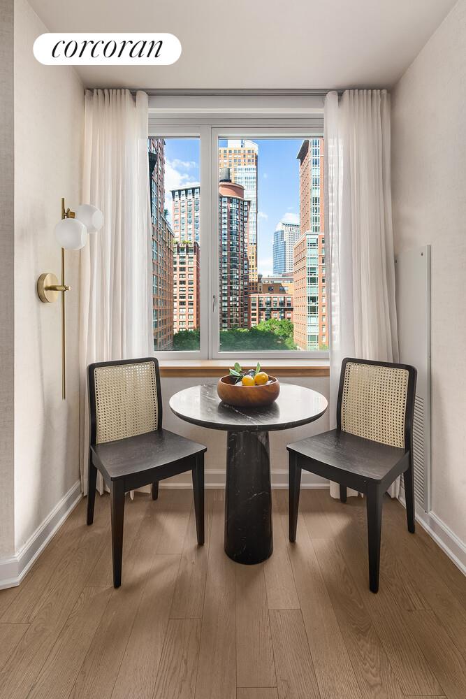 20 River Terrace, Unit 18Q Manhattan, NY 10282 - Photo 2 of 8 a room with a table and a window