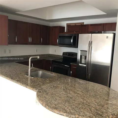 a kitchen with a refrigerator sink and cabinets