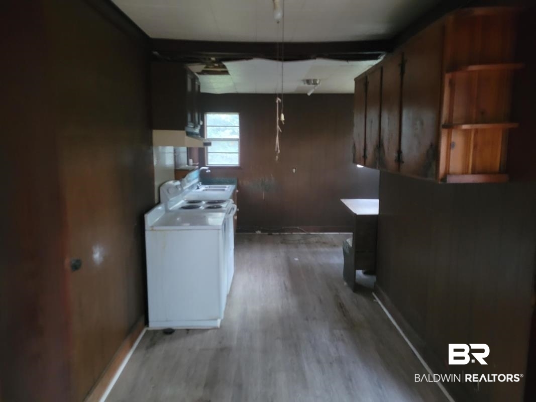 2059 Magnolia Lane Mobile, AL 36605 - Photo 14 of 17 Kitchen with light countertops, light wood finished floors, washer / dryer, and baseboards
