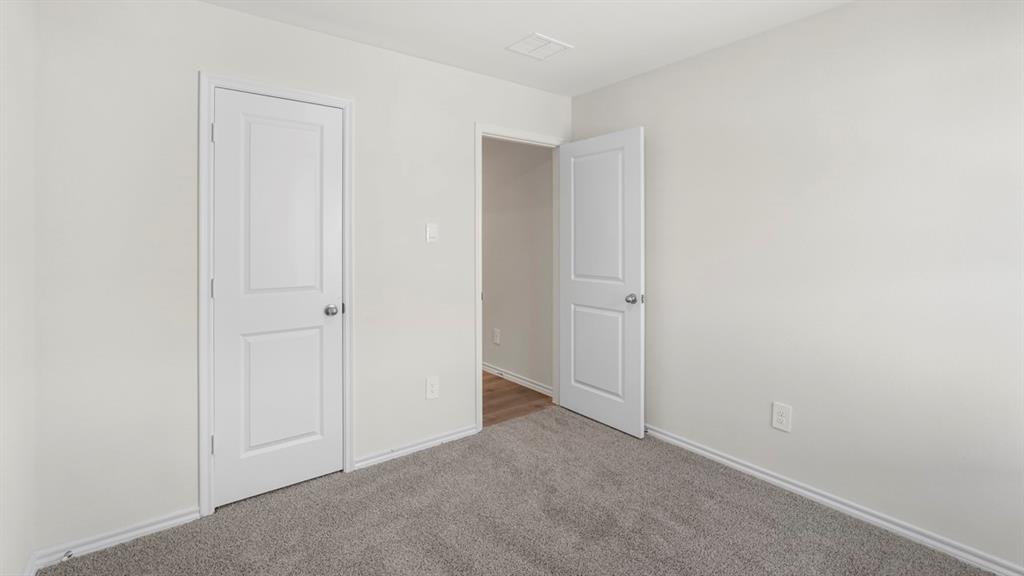 1969 Freeman Street Tyler, TX 75704 - Photo 27 of 30 Neutral painted walls with white trim, gray carpet flooring, and white two-panel doors