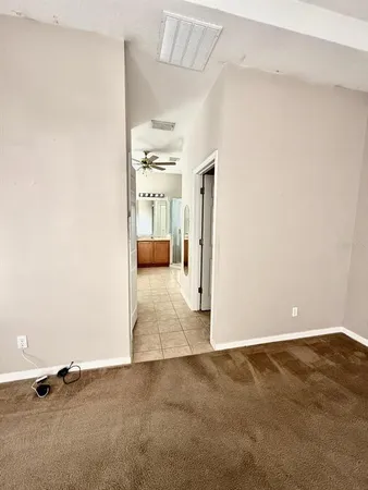 an empty room with kitchen view