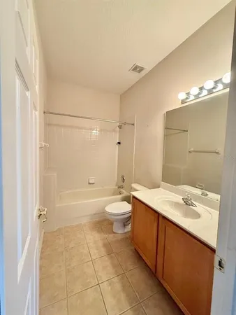 a bathroom with a granite countertop sink toilet a mirror and shower