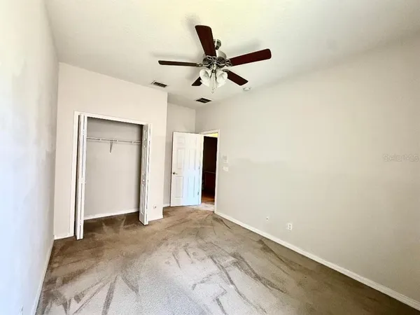 a view of empty room with ceiling fan