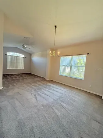 an empty room with windows and ceiling fan