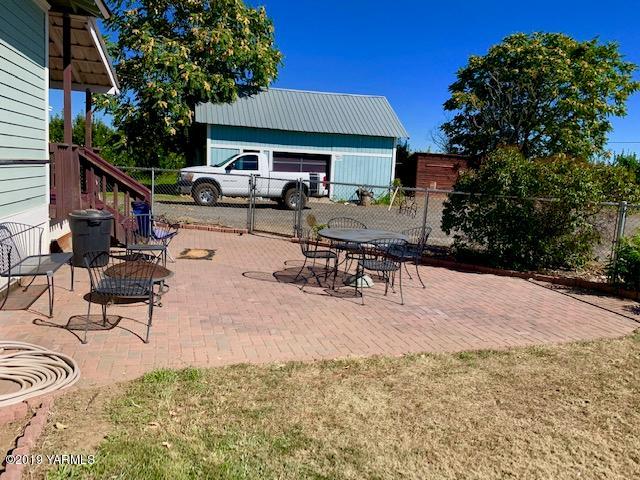 341 Heikle Road Wapato, WA 98951 - Photo 9 of 29 a view of a patio with table and chairs with wooden fence and plants