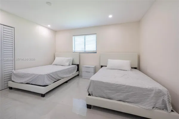 a bedroom with a bed rug and window