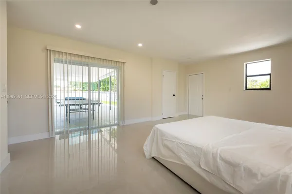a spacious bedroom with a large bed and wooden floor