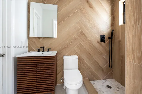 a bathroom with a sink a toilet and shower