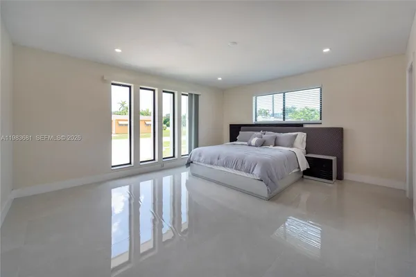 a bedroom with a bed and a large window