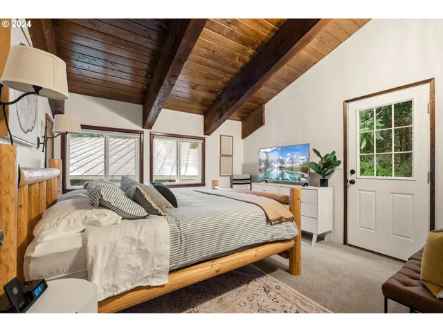 a bedroom with a bed a painting and lamp