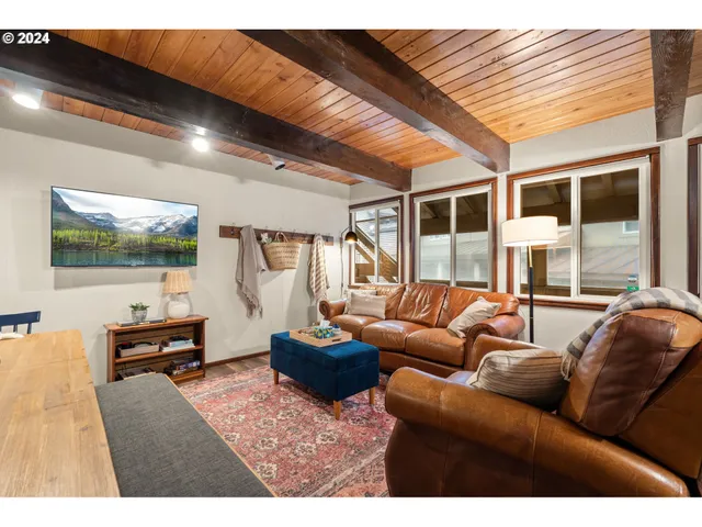 a living room with furniture a flat screen tv and a floor to ceiling window