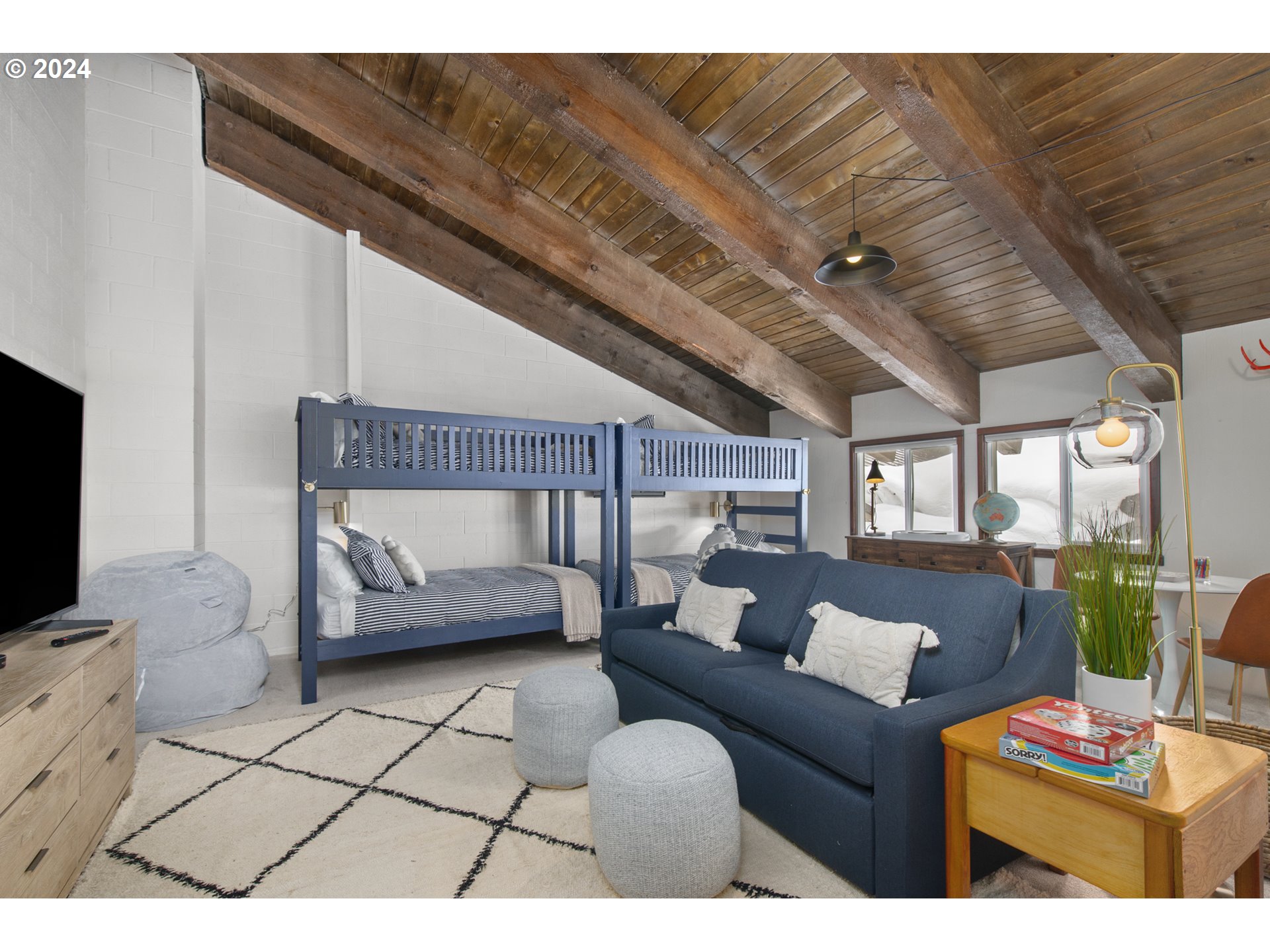 88460 Government Camp Loop, Unit 8 Government Camp, OR 97028 - Photo 21 of 38 a living room with furniture a flat screen tv and a floor to ceiling window