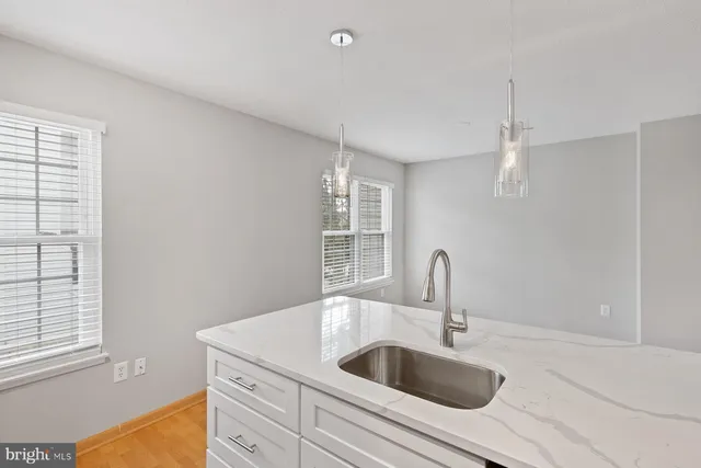 a kitchen with sink a faucet and chandelier