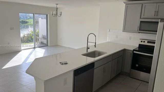 a kitchen with a sink and stainless steel appliances