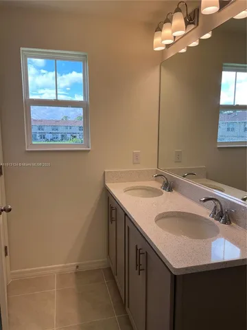 a bathroom with a granite countertop sink a large mirror and a window