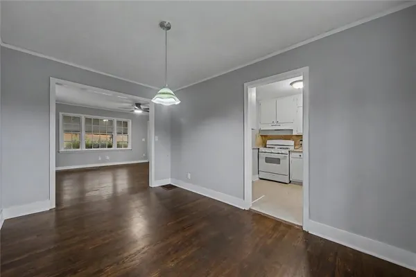a view of a room with wooden floor staircase and a kitchen space