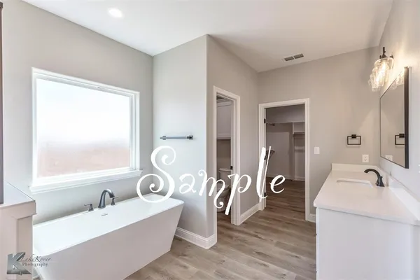a bathroom with a tub sink and mirror
