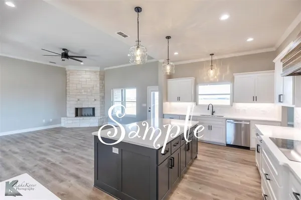 a kitchen with stainless steel appliances granite countertop a sink a stove and a wooden floors