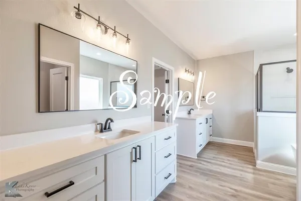 a spacious bathroom with a double vanity sink and a mirror