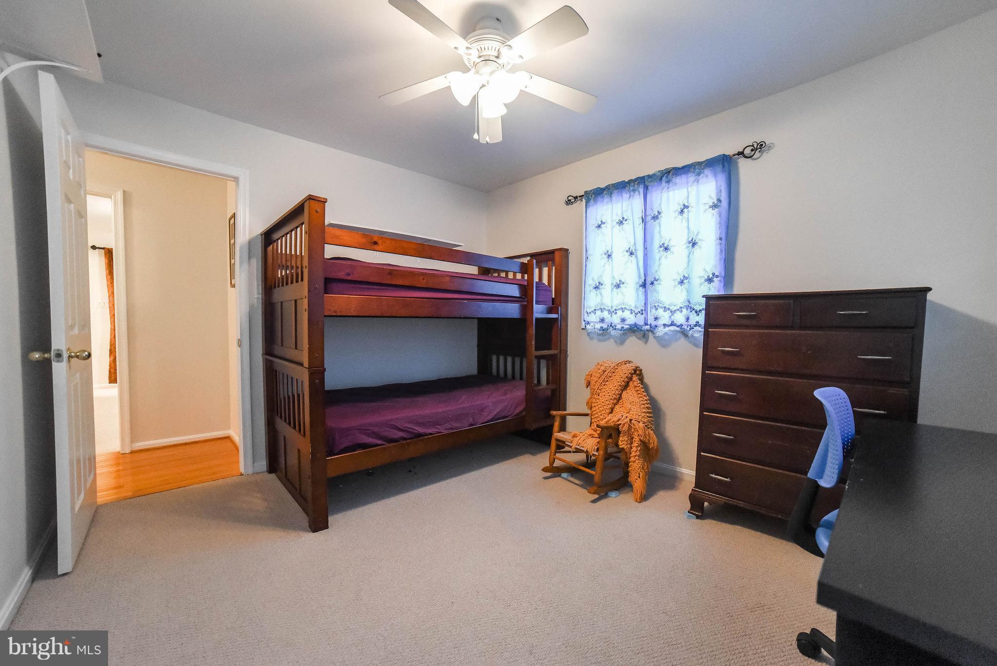 49870 Gray Goose Lane Ridge, MD 20680 - Photo 21 of 30 a bedroom with a bed and a chandelier