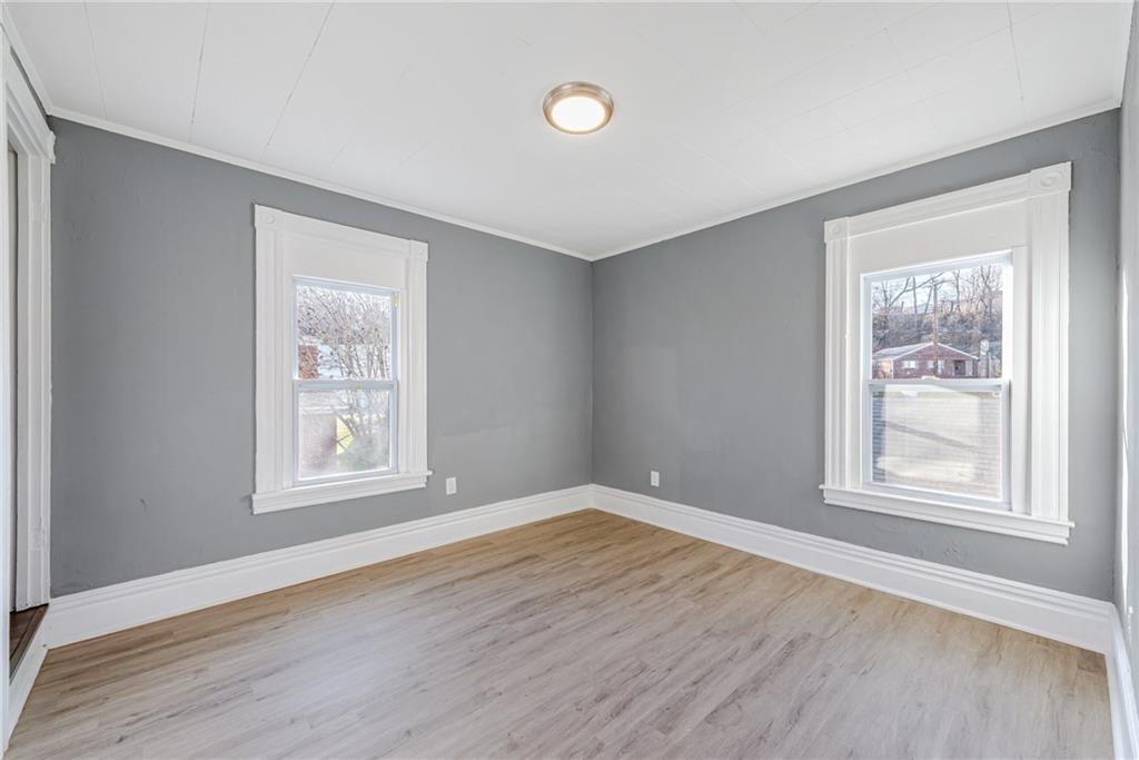 1222 Valley Street McKees Rocks, PA 15136 - Photo 11 of 13 an empty room with wooden floor and windows