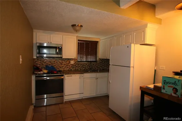 a kitchen with a refrigerator and a sink