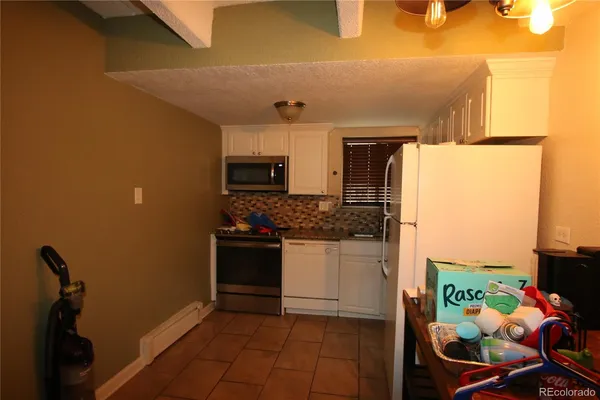 a kitchen with stainless steel appliances granite countertop a refrigerator and a stove