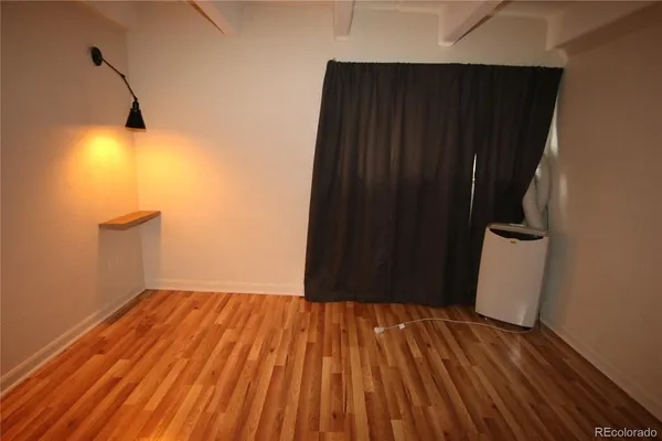 a view of a room with wooden floor and cabinet