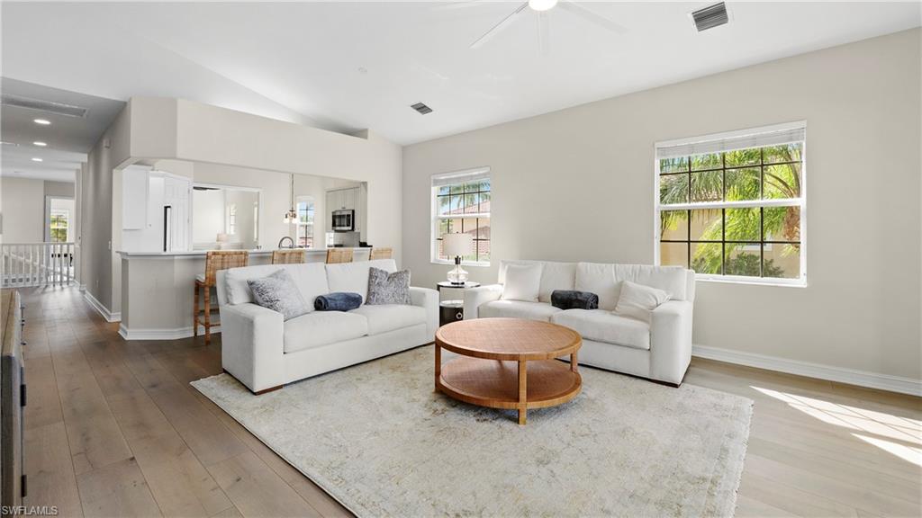 8617 Champions Point, Unit 403 Naples, FL 34113 - Photo 12 of 37 Living area with lofted ceiling, hardwood / wood-style flooring, and ceiling fan