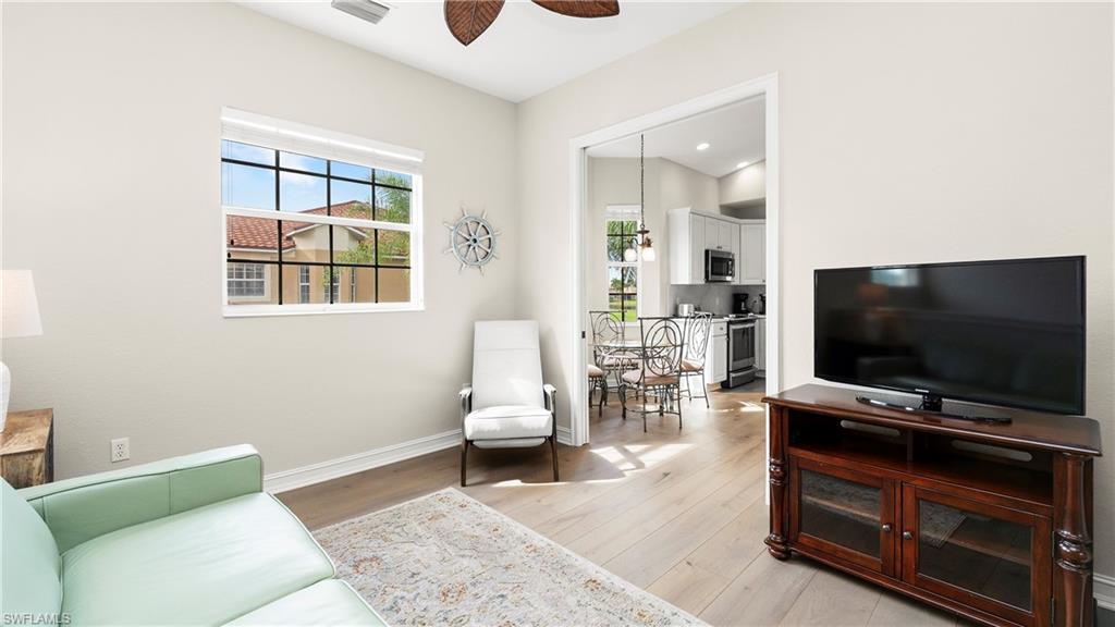 8617 Champions Point, Unit 403 Naples, FL 34113 - Photo 15 of 37 Living area with light wood-style floors and a ceiling fan