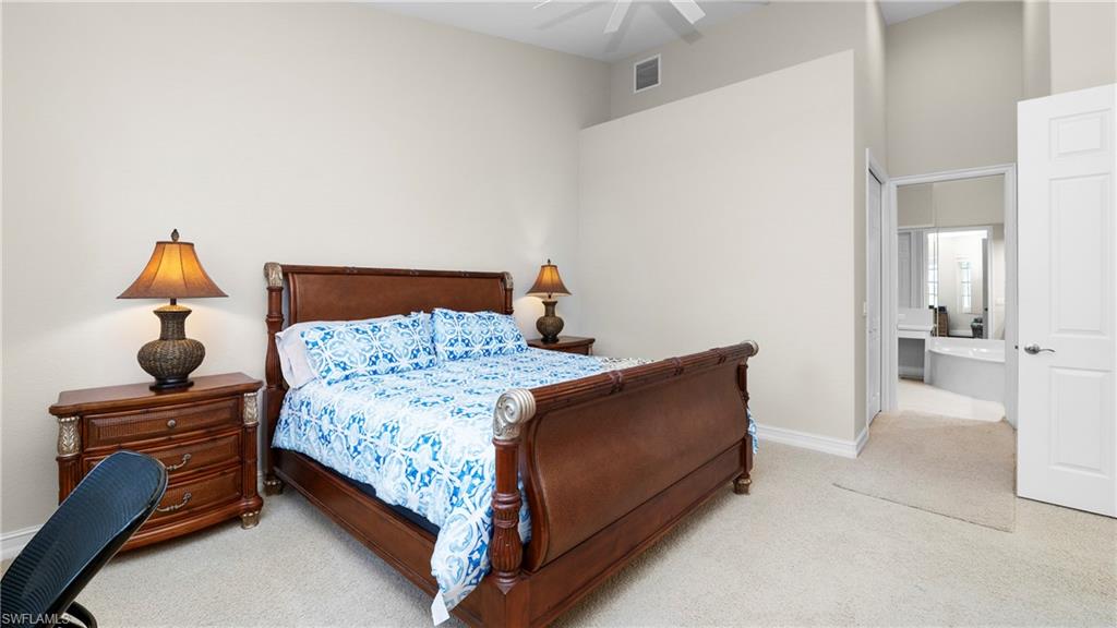 8617 Champions Point, Unit 403 Naples, FL 34113 - Photo 18 of 37 Bedroom featuring light colored carpet, connected bathroom, and ceiling fan