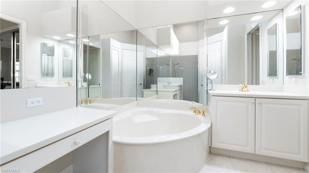 8617 Champions Point, Unit 403 Naples, FL 34113 - Photo 19 of 37 Bathroom featuring a garden tub, recessed lighting, light tile patterned floors, two vanities, and a shower stall