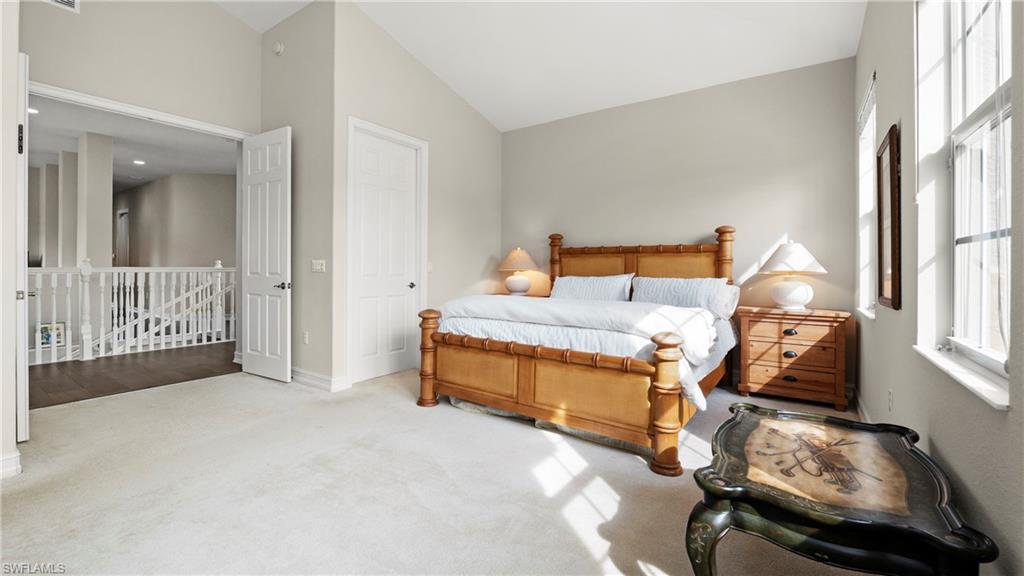 8617 Champions Point, Unit 403 Naples, FL 34113 - Photo 22 of 37 Carpeted bedroom featuring vaulted ceiling