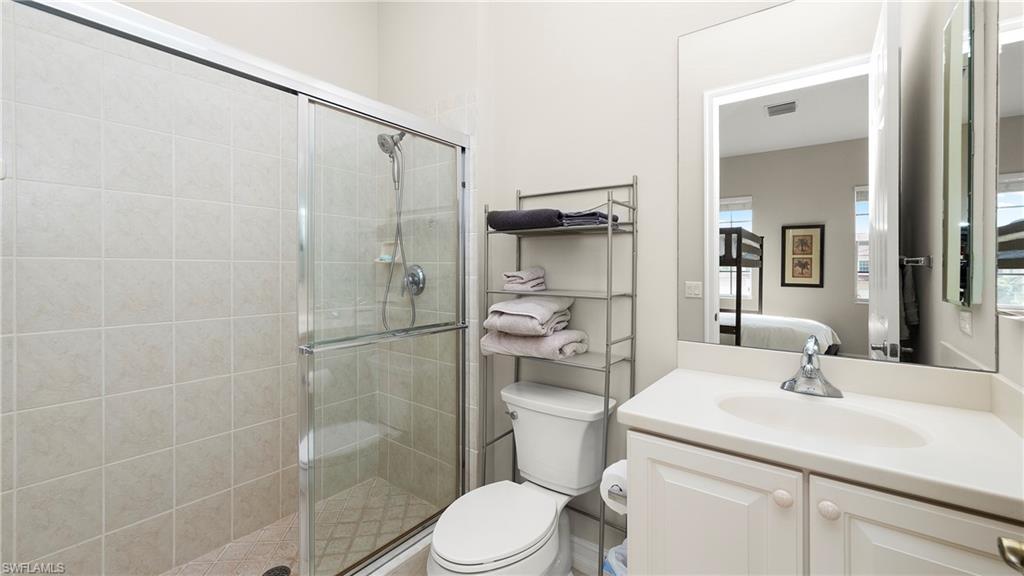 8617 Champions Point, Unit 403 Naples, FL 34113 - Photo 28 of 37 Bathroom featuring a stall shower and vanity