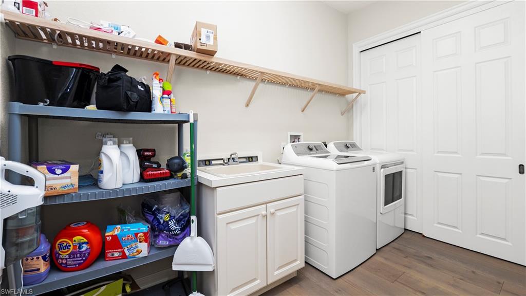 8617 Champions Point, Unit 403 Naples, FL 34113 - Photo 37 of 37 Laundry room featuring dark wood-style floors, independent washer and dryer, and cabinet space