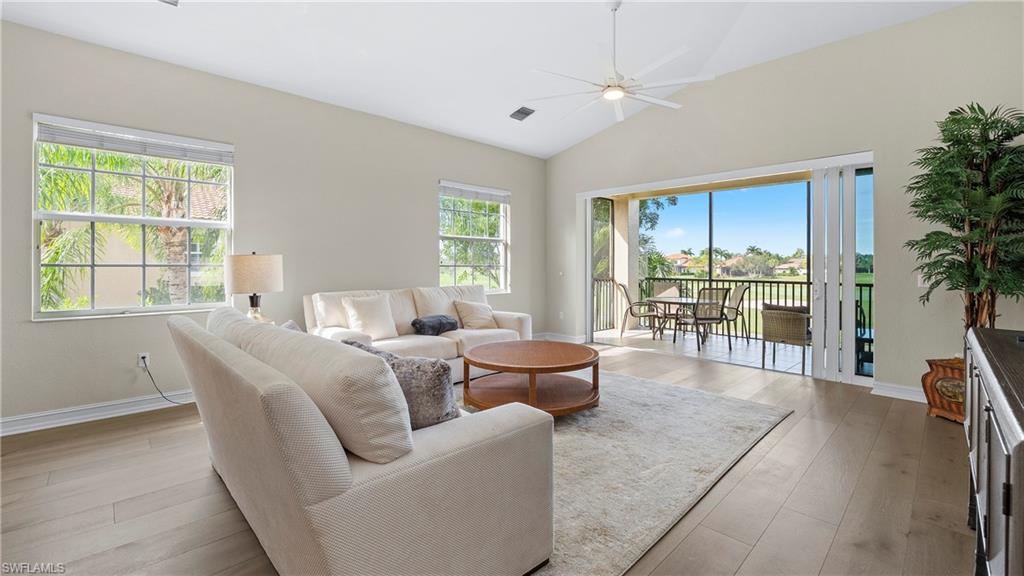 8617 Champions Point, Unit 403 Naples, FL 34113 - Photo 10 of 37 Living area with lofted ceiling, light wood-style flooring, and a ceiling fan