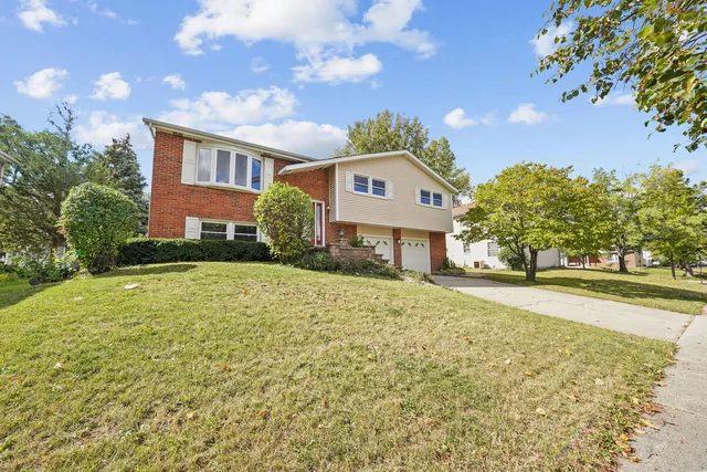 a front view of a house with a yard and trees