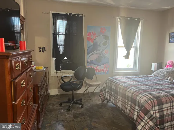 a bedroom with a bed and a mirror on the dresser