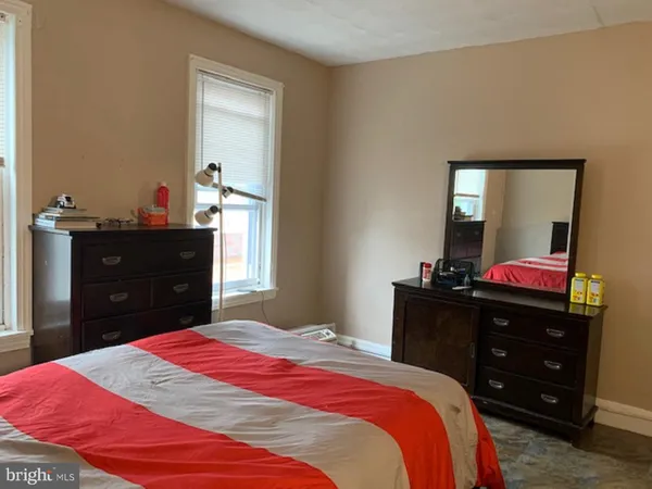 a bedroom with a bed and a mirror on dresser