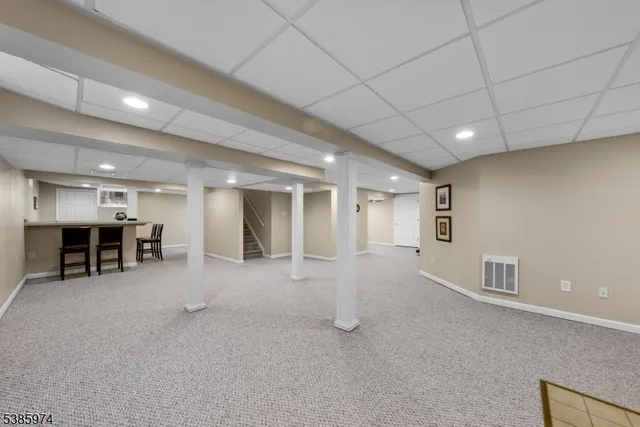 a view of an empty room with furniture and window