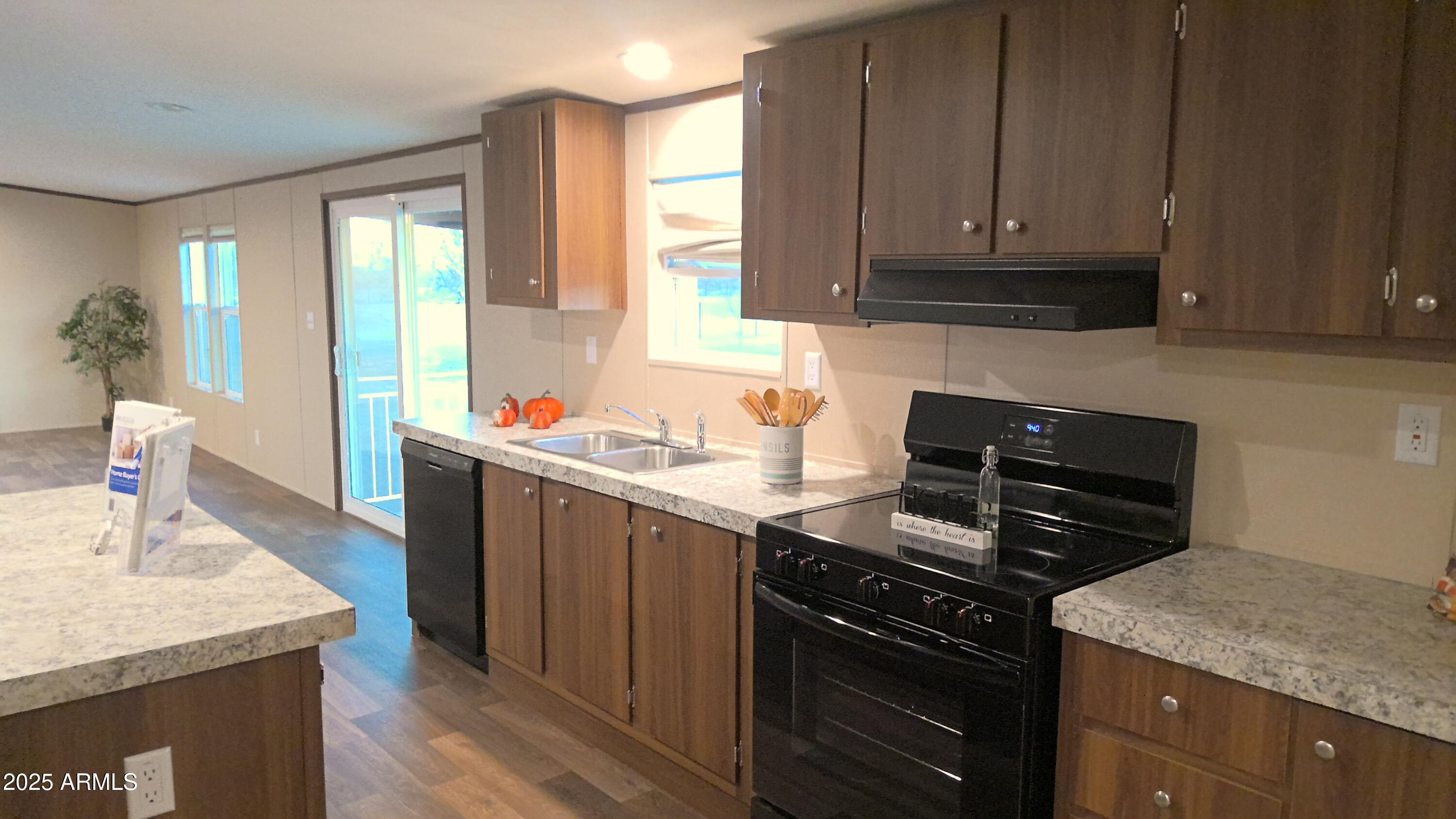 51603 West Pony Road Maricopa, AZ 85139 - Photo 17 of 36 a kitchen with granite countertop a sink stove and cabinets